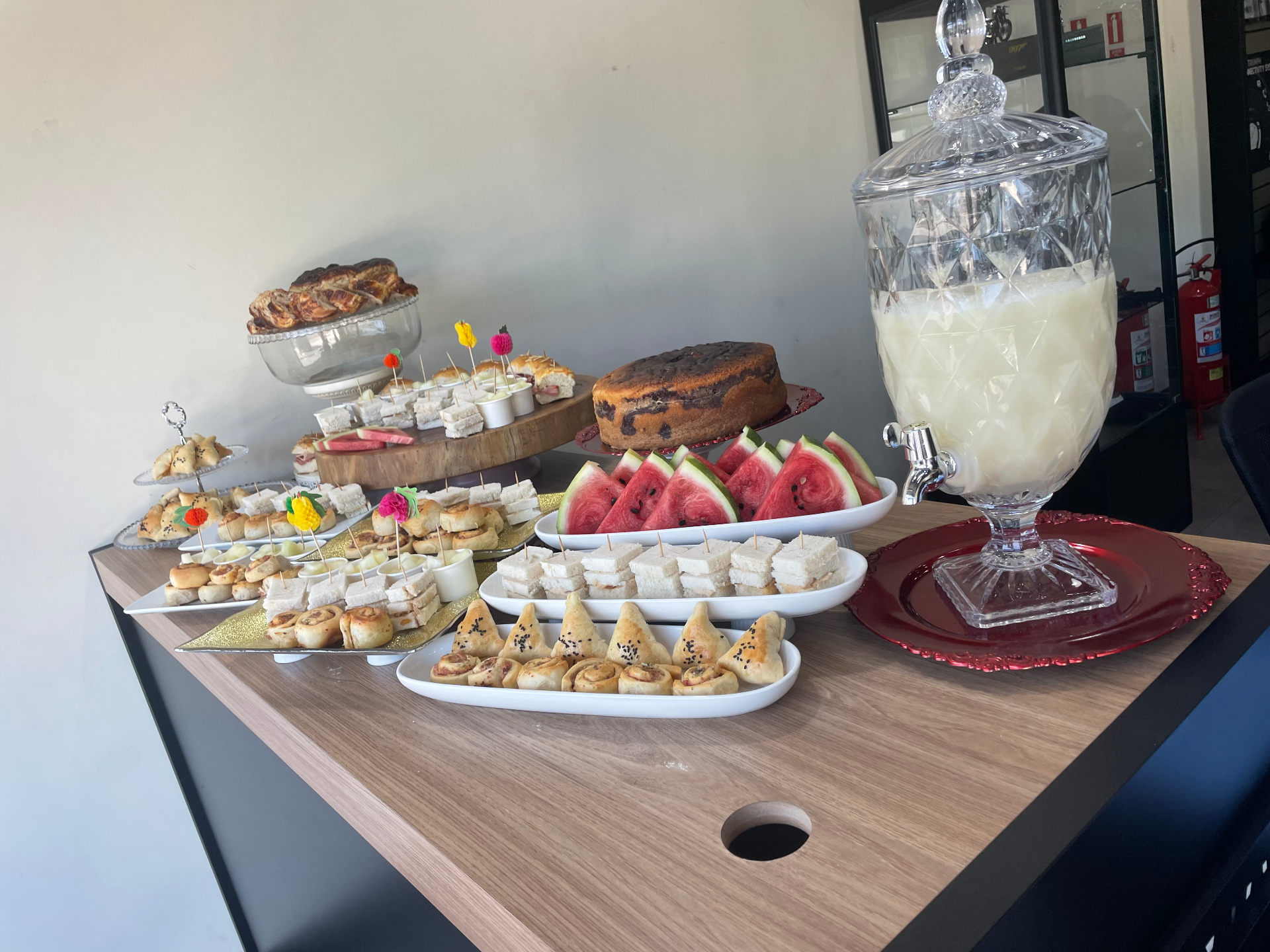 Mesa de café da tarde com salgados, doces e limonada
