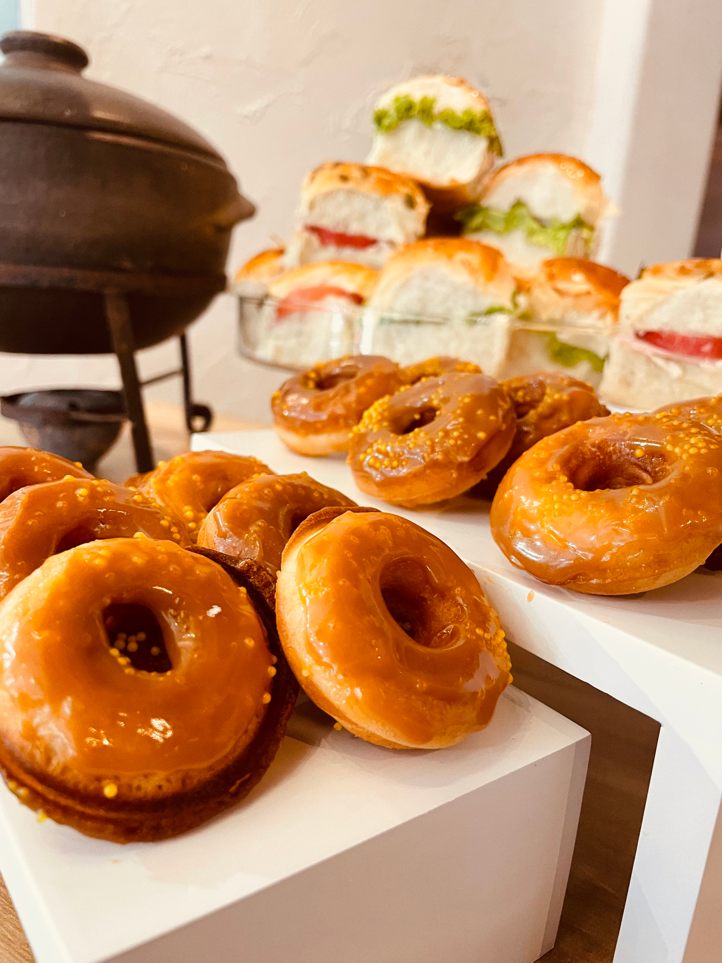 Donuts glaçados de caramelo dispostos em suportes brancos